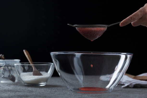 istock Woman straining strawberry jam through a sieve 1332291576