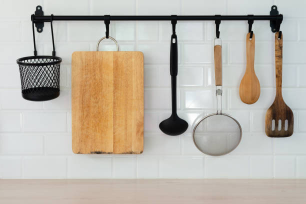 utensílios de cozinha pendurados no rack preto e fundo branco. - cooking kitchen utensil wood isolated - fotografias e filmes do acervo