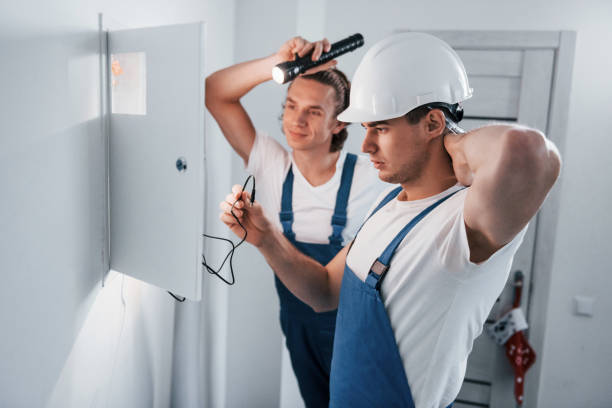 istock Two young male electricians works indoors together. Using flashlight 1332295407