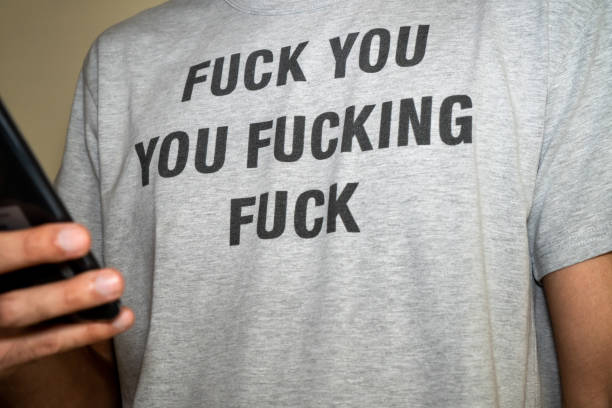 istock Unrecognized man wearing an insulting t-shirt while using a phone. 1332302005