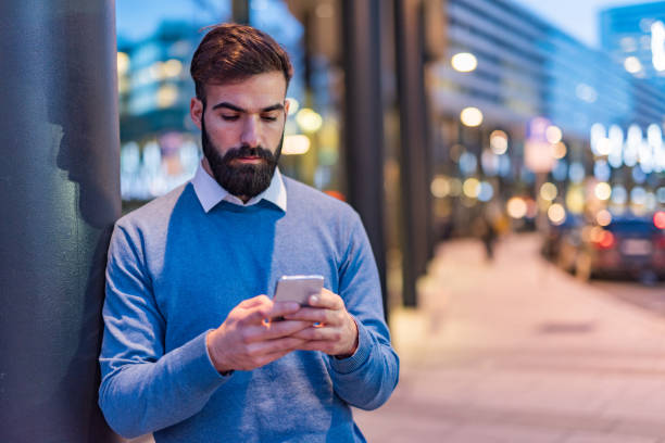 istock Man at night on the streets using phone 1332302383