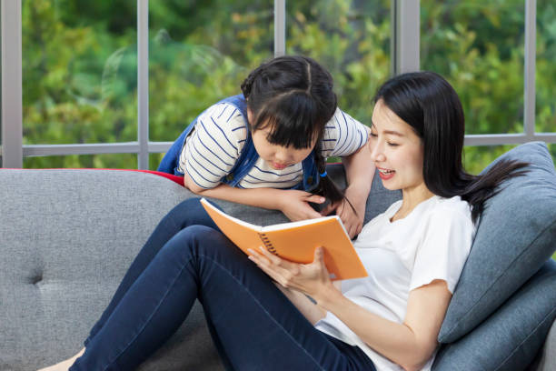 istock Asian mother teaching homework to daughter using on the sofa couch for homeschooling and education 1332303052