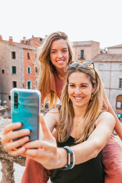 istock Two smiling women friends taking a selfie 1332303413
