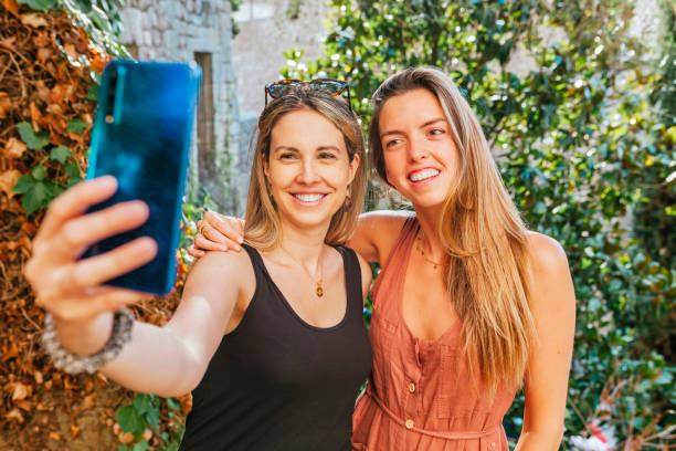 istock Two smiling women friends taking a selfie 1332303425