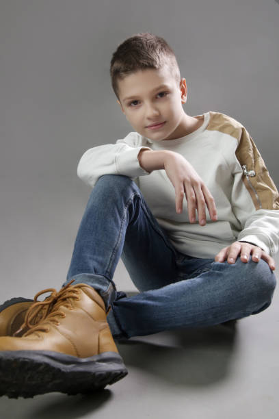 Handsome teenager boy outdoors. Preteen child thinking and sitting in garden.