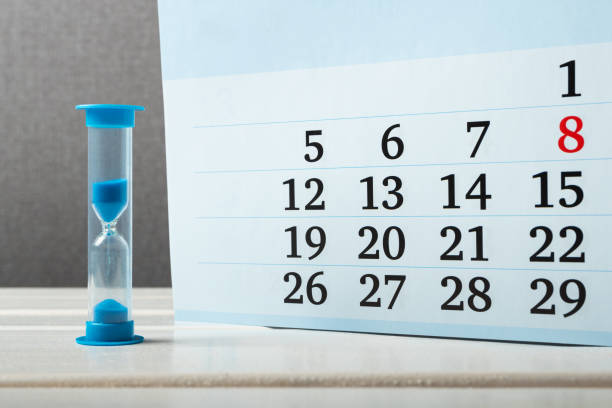 istock hourglass stands near the calendar 1332308887