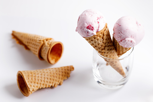 sweet ice cream made of strawberry in cones on white background