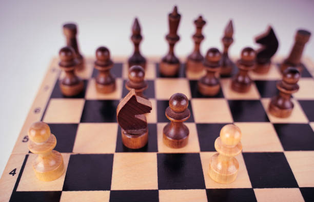 istock White and black wooden pieces on a chessboard. A chessboard set up during a game on a gray background 1332321752