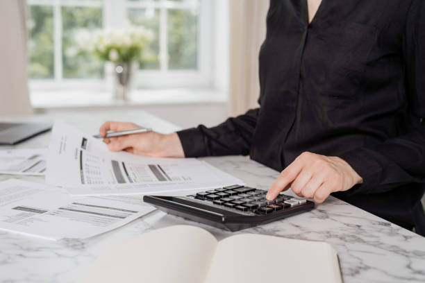 istock Woman using black calculator to calculate payments 1332325654