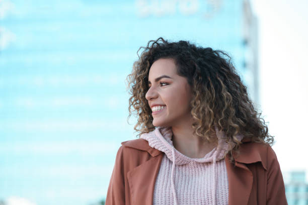istock Latin woman smiling while standing outdoors on the street. 1332328906