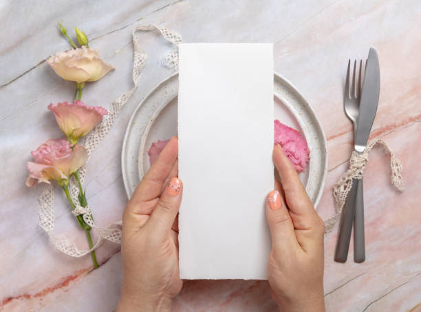 istock Hands holding wedding menu over a ceramic plate on a marble table 1332329169