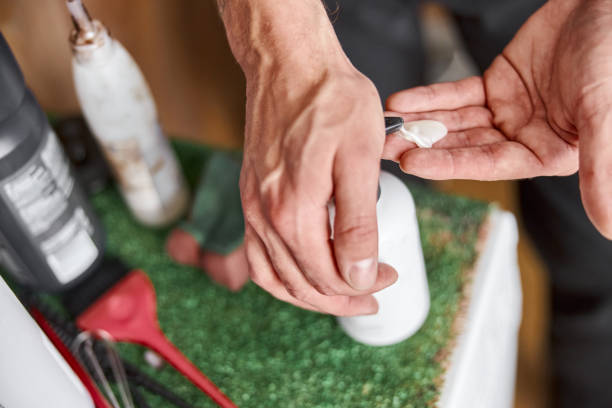 istock Hands of a male master  with cream 1332332840
