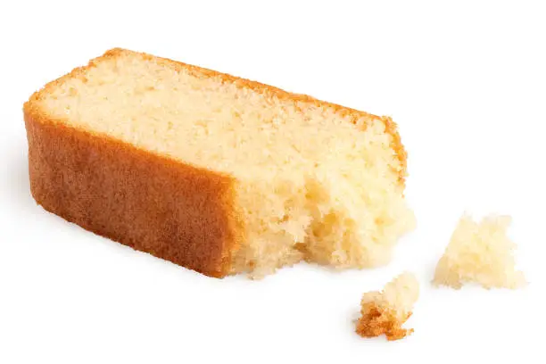 Partially eaten slice of plain sponge cake lying flat isolated on white. With crumbs.