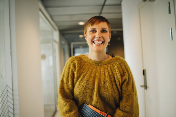 istock Happy woman standing in office corridor 1332335648