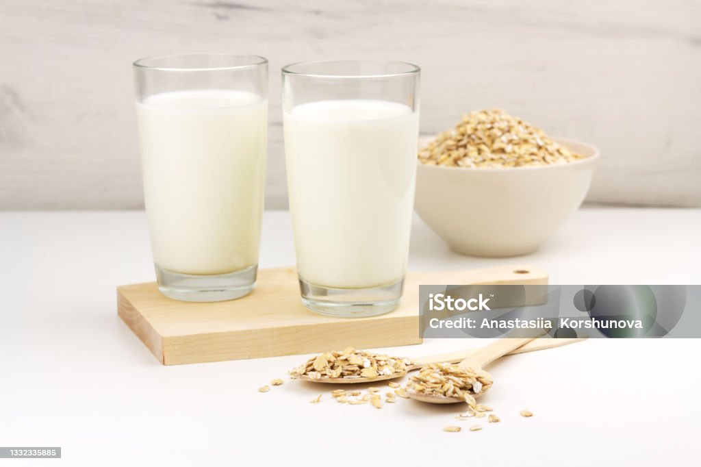 Lait d’avoine sans produits laitiers et flocons dans un bol sur fond clair - Photo de A la mode libre de droits Lait d’avoine sans produits laitiers et flocons dans un bol sur fond clair - Photo de A la mode libre de droits