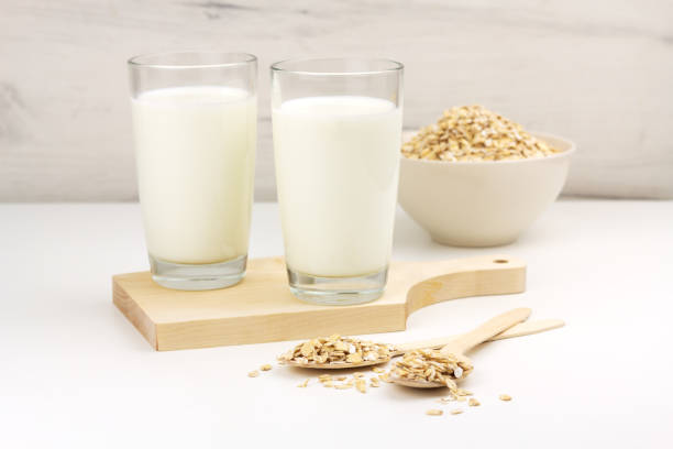 istock Dairy free oat milk and flakes in a bowl on light background 1332335885