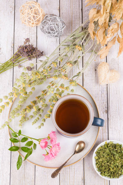 istock Green tea or herbal tea with cup, sugar and dry herbs 1332337945