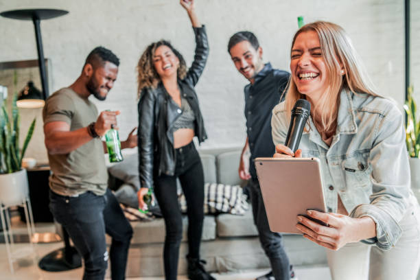 istock Group of friends playing karaoke at home. 1332338413