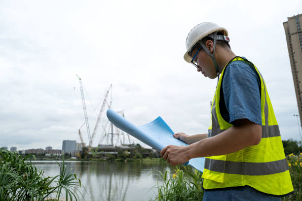 istock Male engineer looking at blueprints at construction site 1332339379
