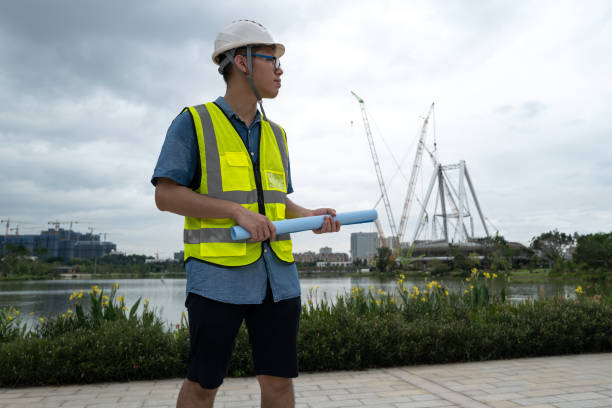 istock Male engineer holding blueprints at construction site by the water 1332339510