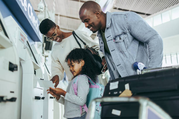 tourist family doing self service check-in for flight - self service stockfoto's en -beelden