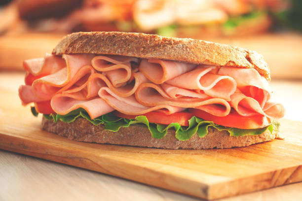 panino con prosciutto affumicato e lattuga fresca - panino ripieno foto e immagini stock