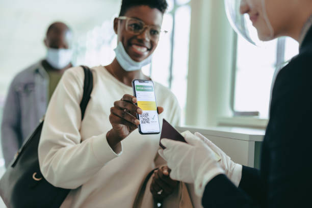 une femme montrant un passeport vaccinal à l’aéroport - personnel aérien au sol photos et images de collection