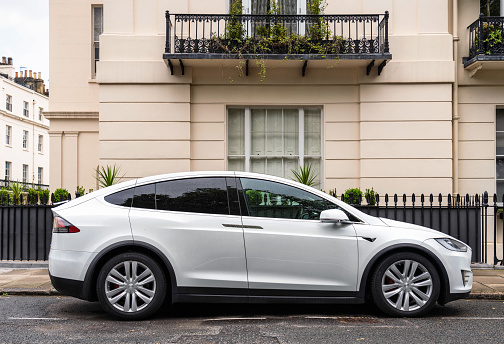 London, UK - Side view of a white Tesla Model X P90D, parked on a residential street in London's Belgravia district.