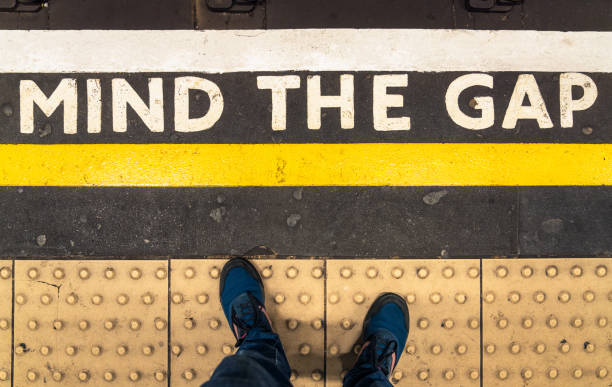 Mind The Gap warning on London Underground London, UK - A personal perspective looking down at a 'Mind The Gap' warning at the edge of the platform at a London Underground station. separation stock pictures, royalty-free photos & images