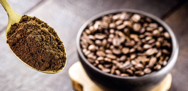 istock golden metal spoon with ground coffee. Roasted seeds in blurred background and copyspace 1332346151
