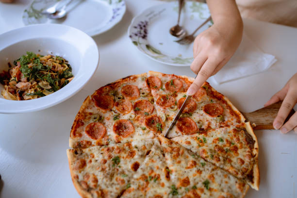 Young Asian couple sharing Italian food at local restaurant.