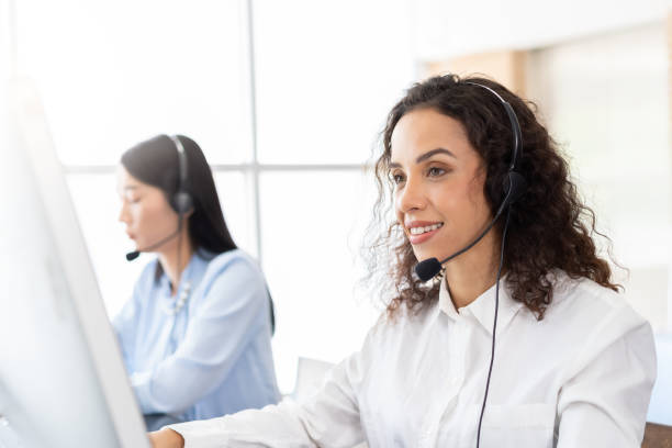 istock Team of call center female worker at work. Women customer support operator with headset working in the office. Contact center and customer service by headphone concept 1332349948
