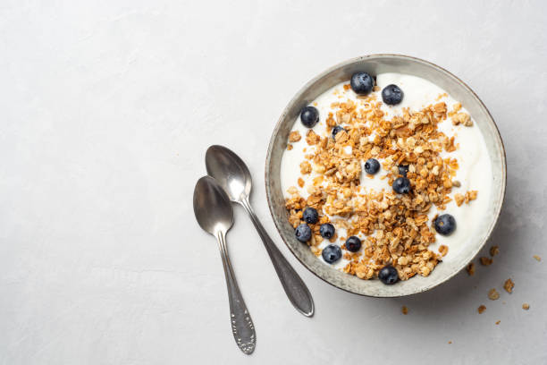 istock Yogurt with granola and blueberries in bowl on concrete background 1332351630