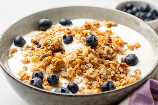 istock Yogurt with granola and blueberries in bowl on concrete background 1332351632