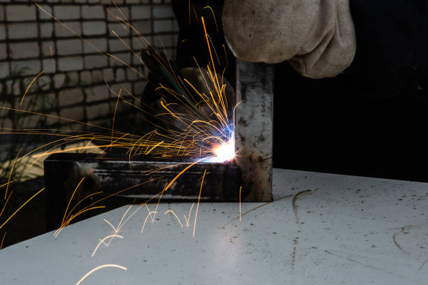 istock A man welder with construction gloves and a welding mask is welded with a welding machine metal outdoor. 1332353014