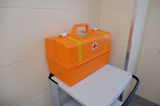 Novokuznetsk/Russia-09.07.2021.an orange medical briefcase of an ambulance doctor with medicines and bandages is on the couch.