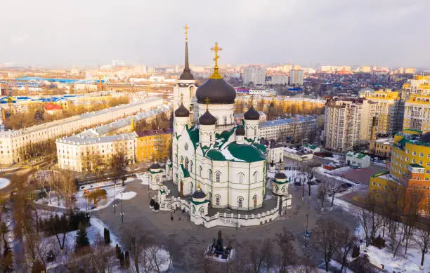 Aerial view of five-domed building of Annunciation Cathedral with attached bell tower in Voronezh on background with winter cityscape, Russia