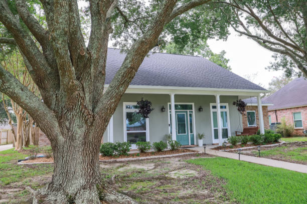 a front view of an acadian renovated home with columns, sidewalks and a colorful front door recently purchased with the changing real estate market - roof tile architectural detail architecture and buildings built structure imagens e fotografias de stock