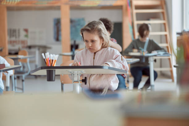istock Very young happy kids are doing lessons in elementary school 1332359724