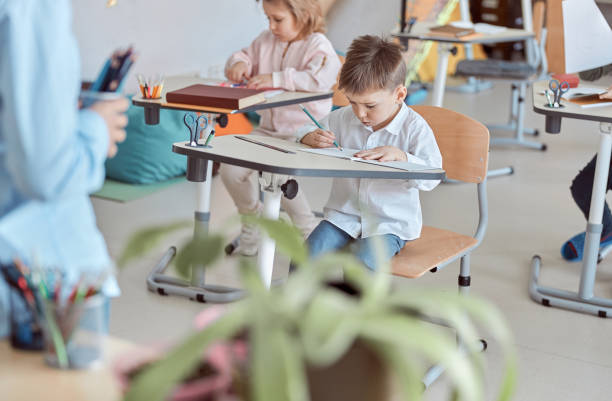 istock Lesson with adorable little students in elementary school 1332359745
