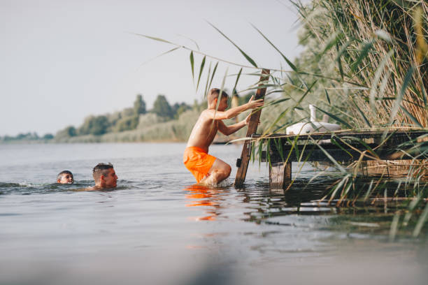 istock Boy is getting out of water, while his friends are still in river. 1332361036