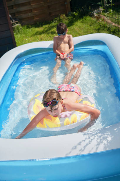 istock Backyard Water Fun Cute Little Kids Playing in Swimming Pool 1332363242