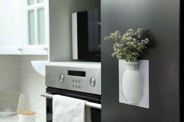 istock Silicone vase with beautiful gypsophila flowers on fridge in kitchen, space for text 1332364302