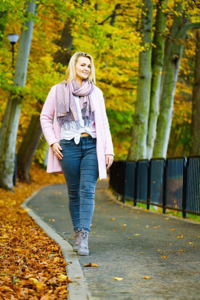 istock Woman walking in autumn park 1332366786