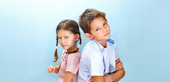 Quarrel of children in the family. The relationship between children and childhood jealousy. The girl shows her fist to the boy.