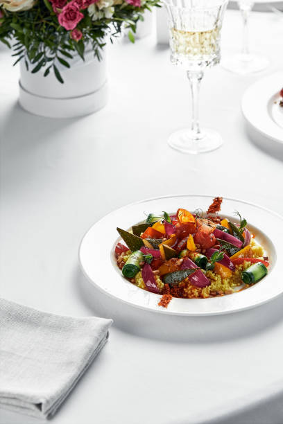 istock Stewed vegetables with coarsely chopped zucchini, carrots, eggplants and bell peppers, table with white tablecloth, copy space 1332368942