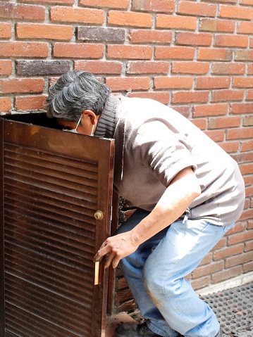 adult man opening the door of a small cellar