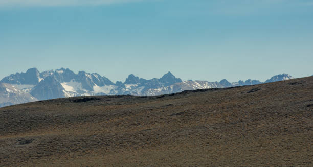 istock Sierra Nevada mountains peaking over a grassy hill 1332375156