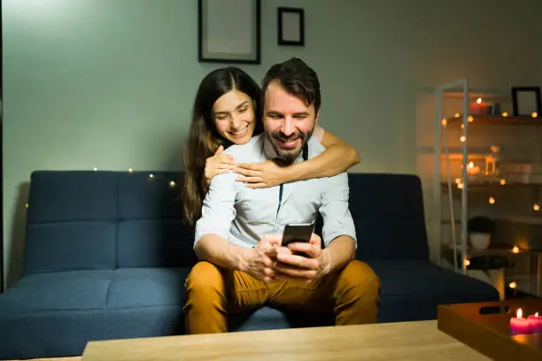 Photo of Excited couple watching an online video