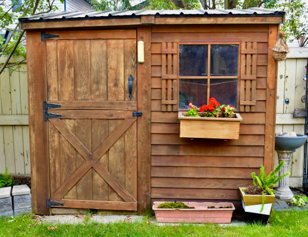 Old textured wooden doors with glass inserts on the side of a barn.
